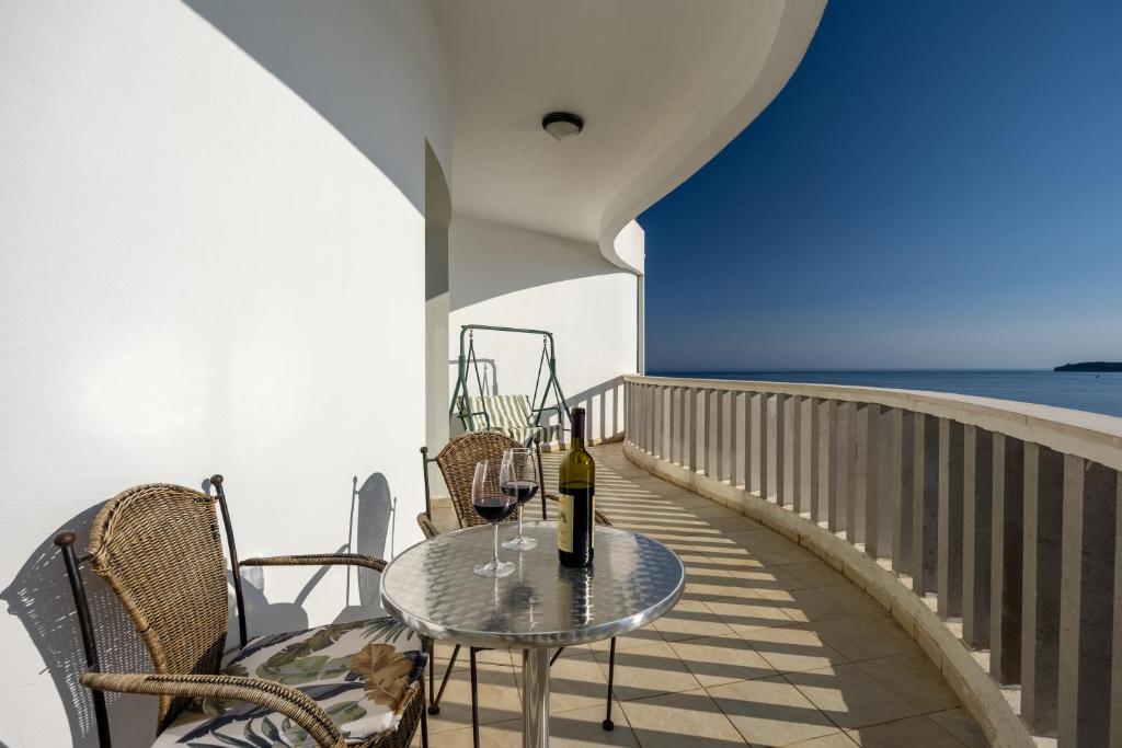 a table with a bottle of wine on a balcony at Adrian in Rafailovici