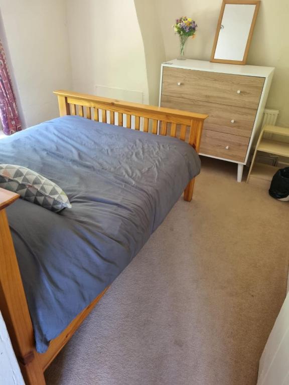 a bed in a room with a dresser and a drawer at 1 Bed Flat Northumberland Heath in Erith