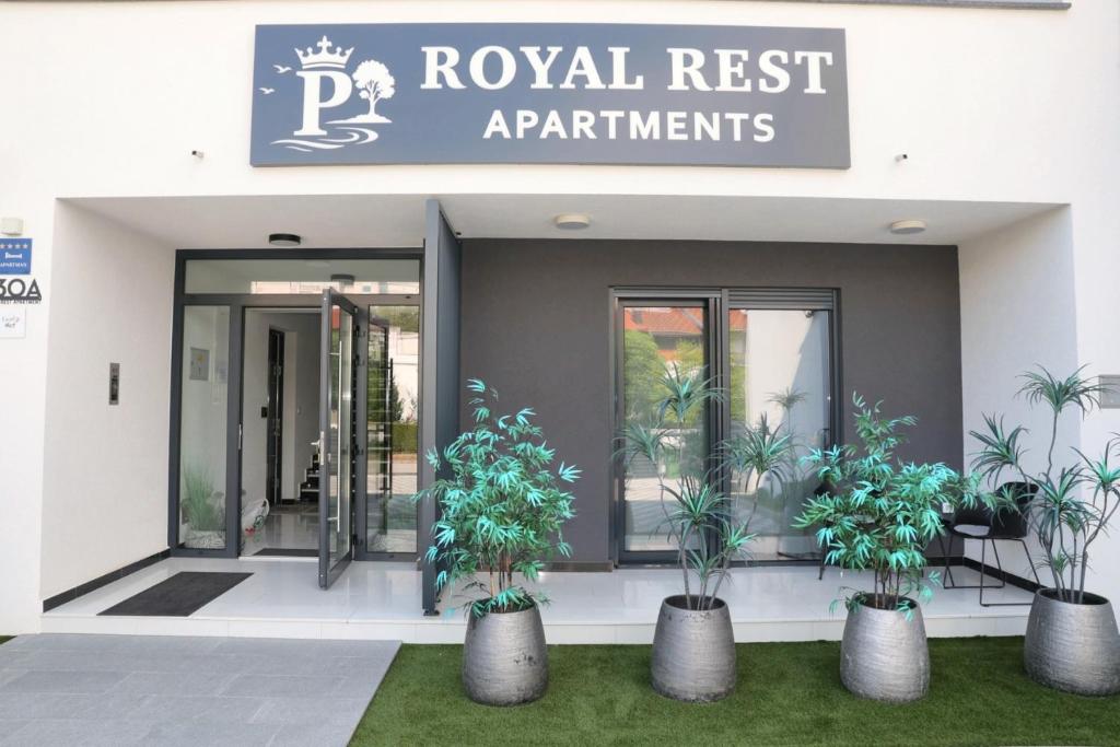 a building with three potted plants in front of it at Royal Rest Apartments Karlovac-Luxury, Central Location & Free Parking in Karlovac