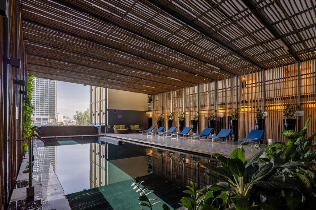 a pool in a building with blue chairs next to it at Hotel Maya Kuala Lumpur City Centre in Kuala Lumpur