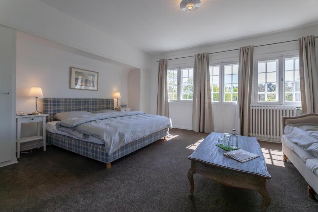 a bedroom with a bed and a coffee table at Hotel Waldhof auf Herrenland in Mölln
