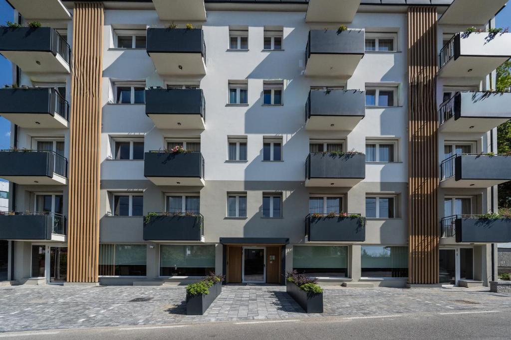 a facade of a building with potted plants at The Circle Bike Residence by Rent All Como in Tavernerio