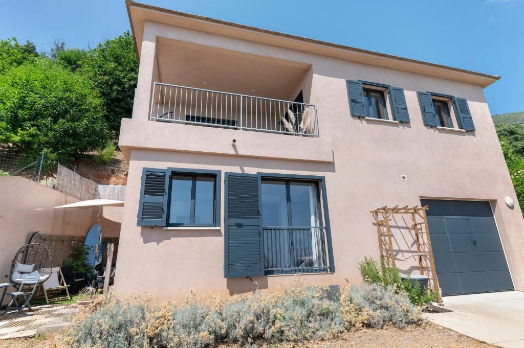 a house with a balcony with a dog on it at Casa Alena in Cervione