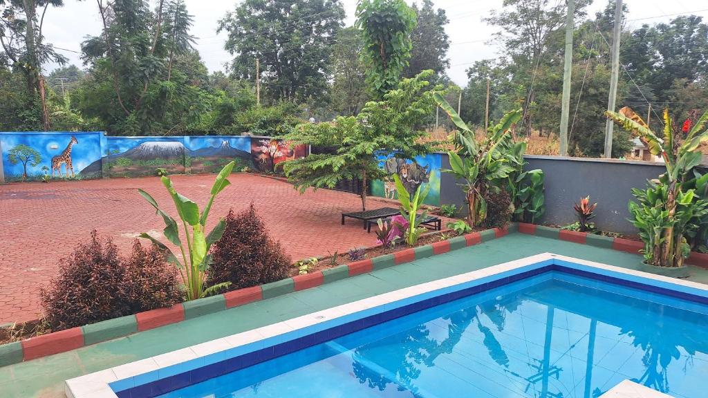 a swimming pool in a backyard with a garden at Escape Villa - Kilimanjaro in Moshi