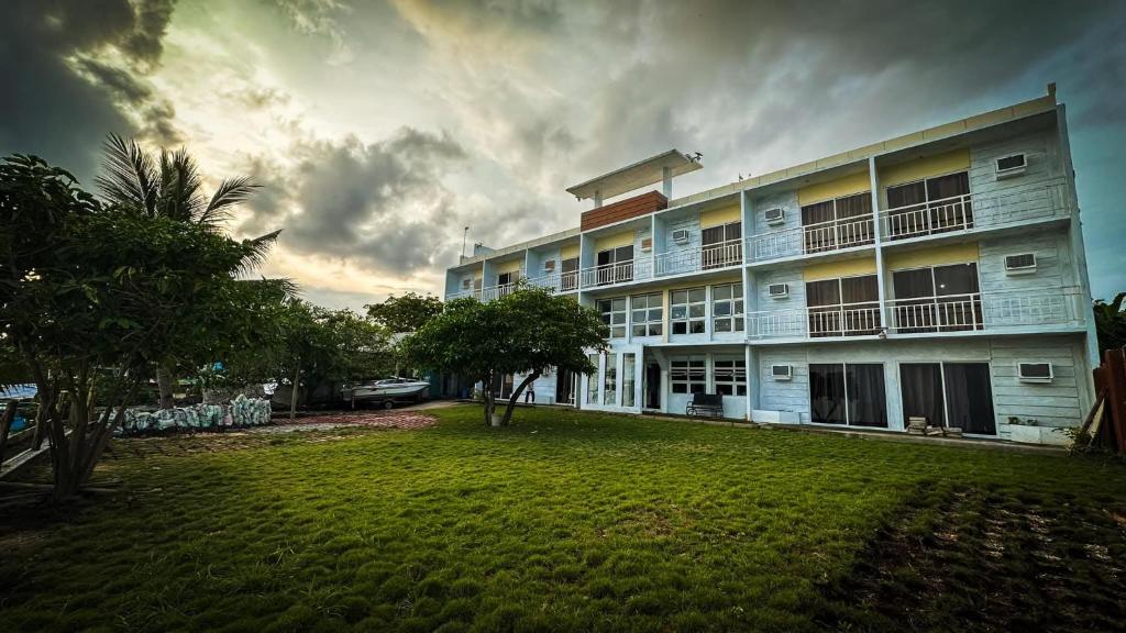 a large building with a lawn in front of it at Dapdap Shorelines Beachfront Villa in Camotes Islands
