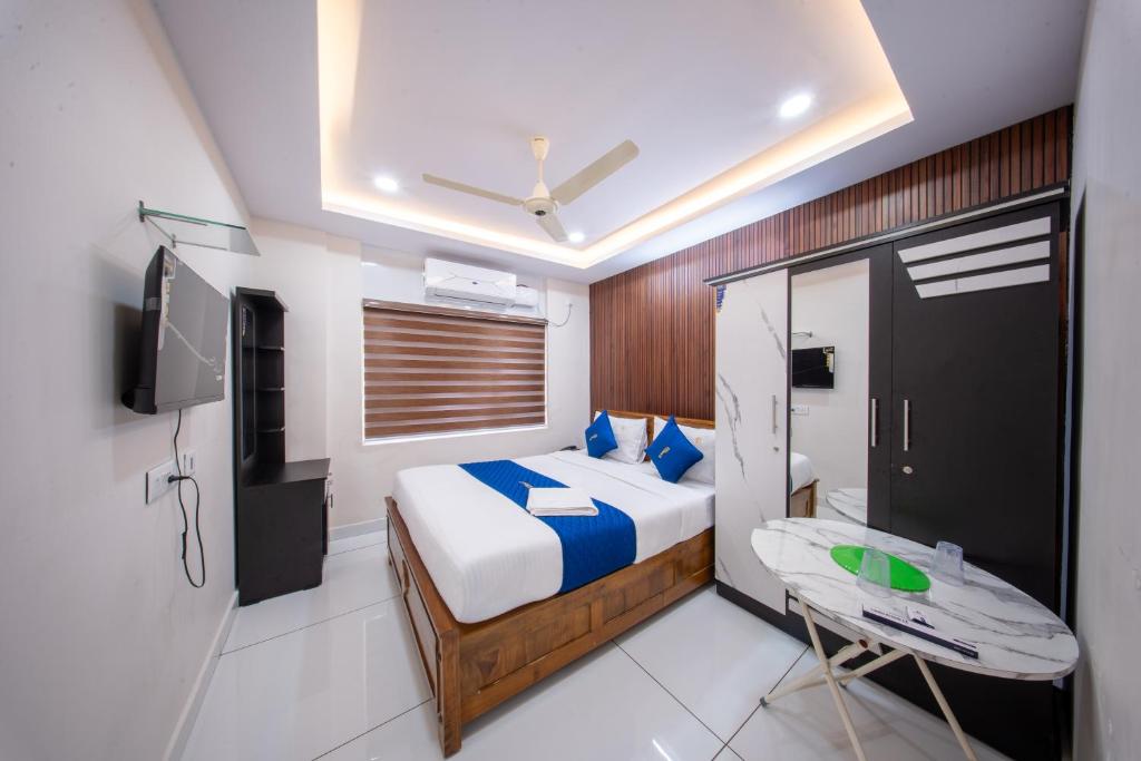 a bedroom with a bed and a desk and a tv at BREEZA GRANd in Kazhakuttam