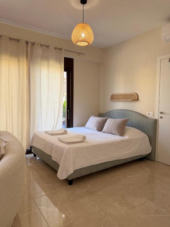 ein Schlafzimmer mit einem Bett und einer Pendelleuchte in der Unterkunft Casa NiMa in Metókhion Apisianá