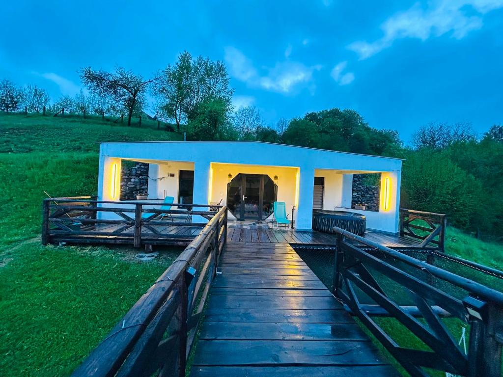 a house on a wooden walkway with a building at Hobbitul lui Maș in Valea lui Maş