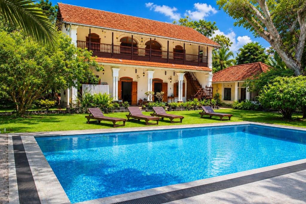a villa with a swimming pool in front of a house at Agwe Villa - Hikkaduwa in Dodanduwa