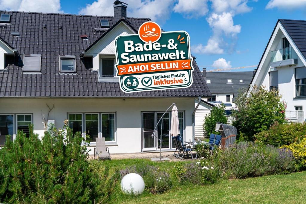 a building with a sign for a barbecue and sampler restaurant at Ferienhaus "Stella Olivia" - Bade- & Saunawelt täglich inklusive in Lobbe