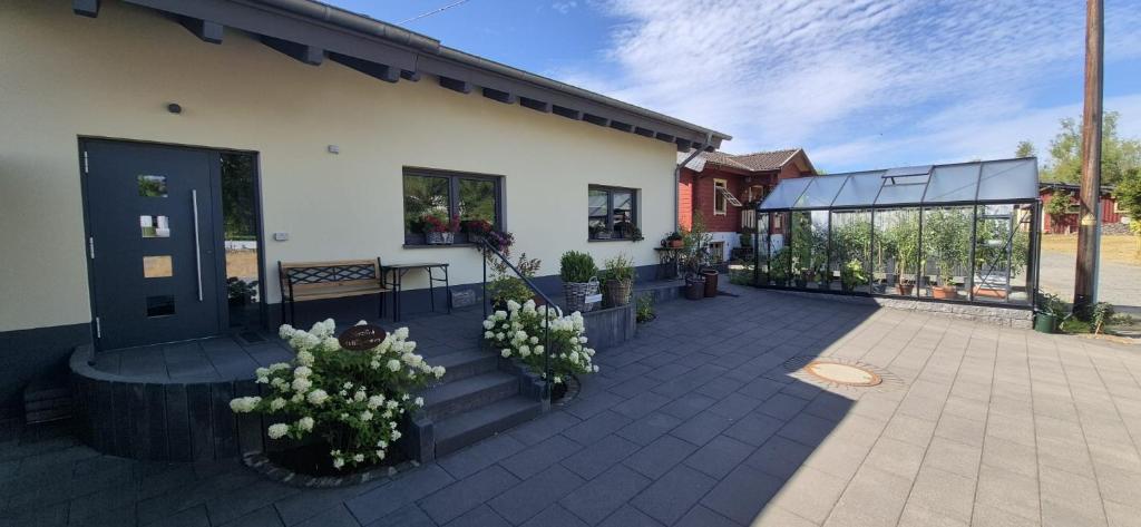 a patio with white flowers and a building at Gästehaus Hähnchenbach in Kelberg