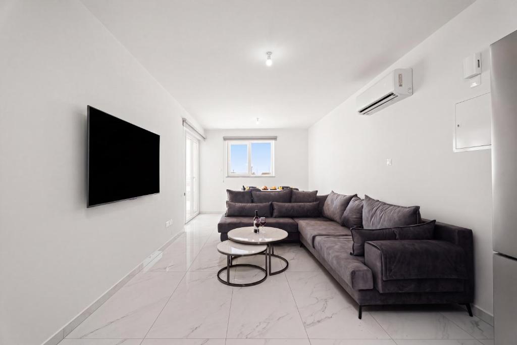 a living room with a couch and a table at Oasis Luxury Escape in Xylophaghou