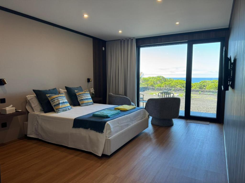 a bedroom with a bed with a view of the ocean at RR Suites in São Mateus