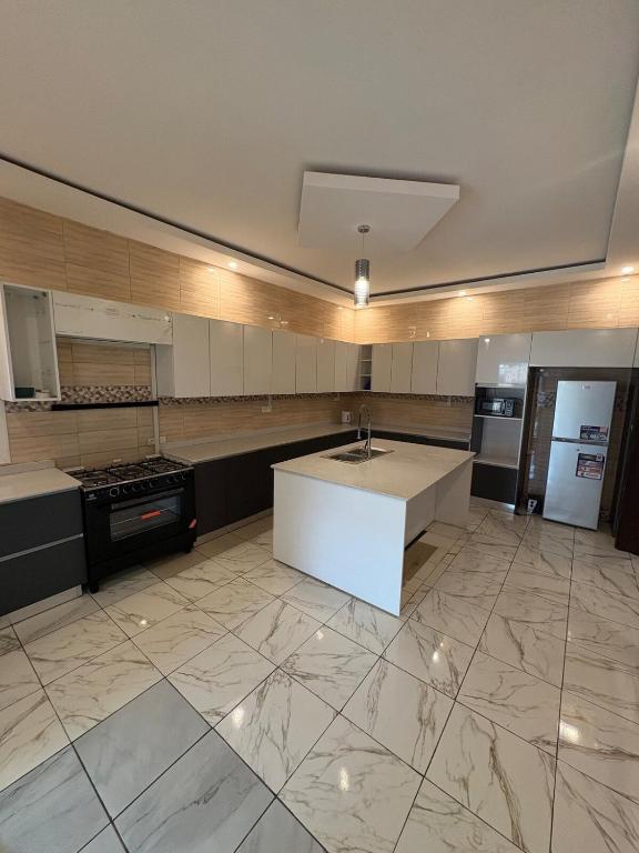 a large kitchen with a sink and a counter top at Campbell Residence Bouaké in Bouaké