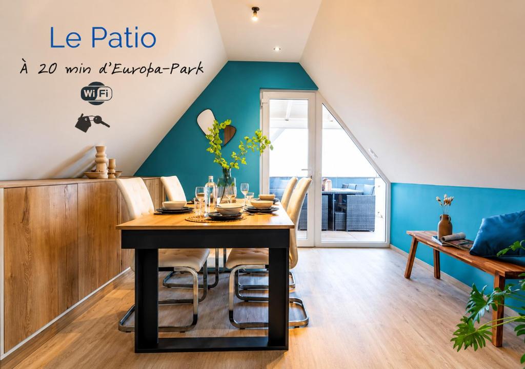 a dining room with a table and blue walls at Le Patio - à 20 minutes d'Europa-Park in Rhinau