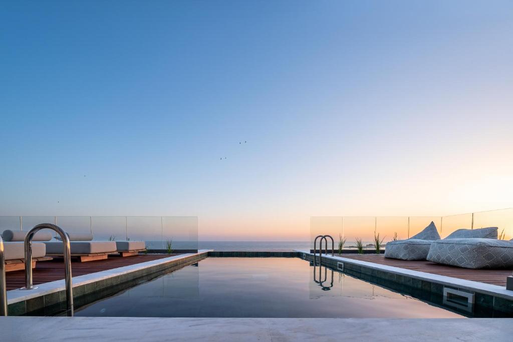a hotel swimming pool with a view of the ocean at Poseidon by Deserve in Paphos