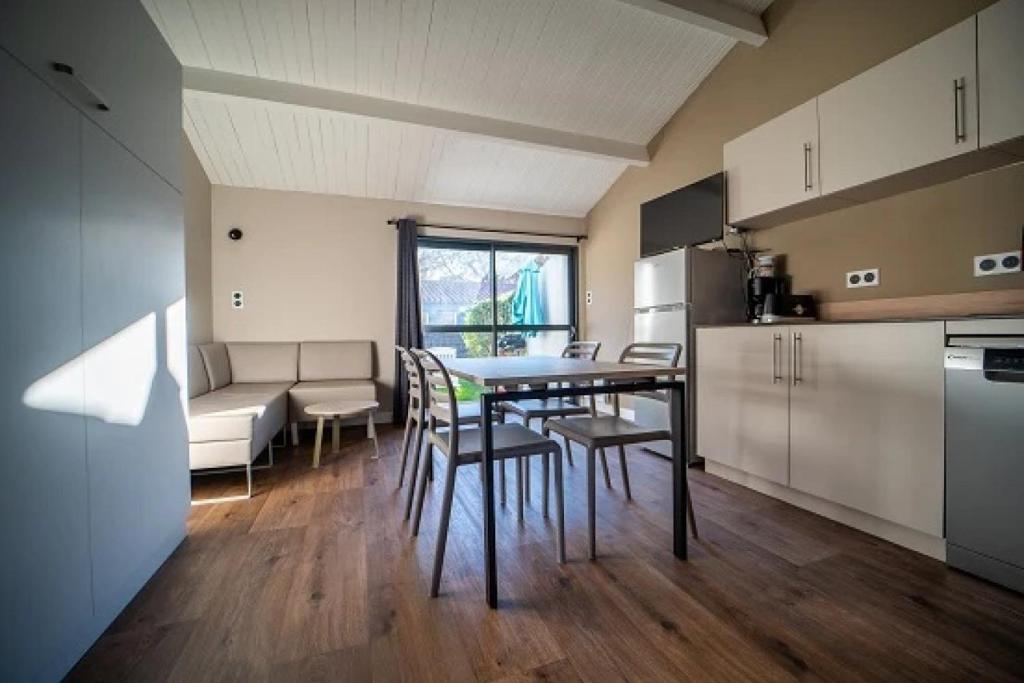 a kitchen and dining room with a table and chairs at Camping 5 étoiles - Parc aquatique - eecdae in Saint-Jean-dʼOrbetiers