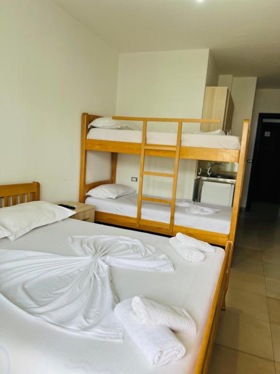 a room with three bunk beds with towels on them at Apartament bisaku in Shëngjin