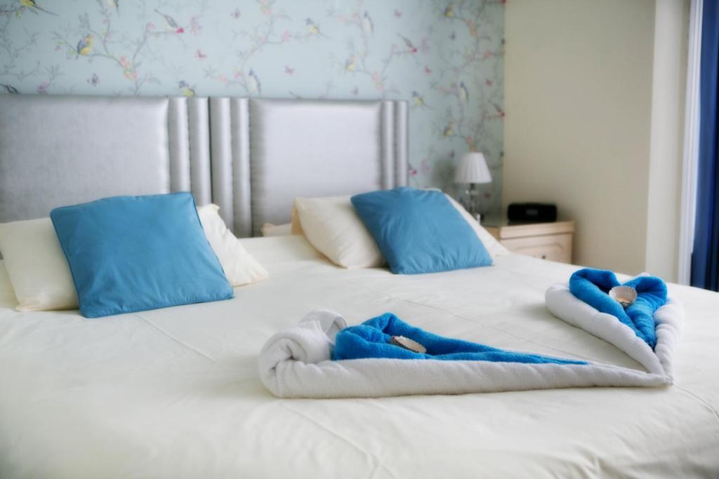 Una cama con dos personas en toallas. en The Haldon Guest House en Paignton