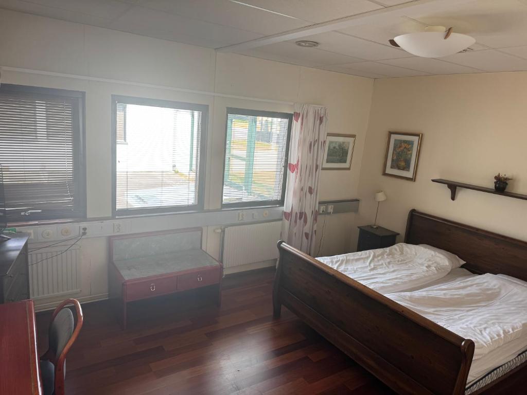 a bedroom with a bed and two windows at Carlssons matsalar in Gislaved