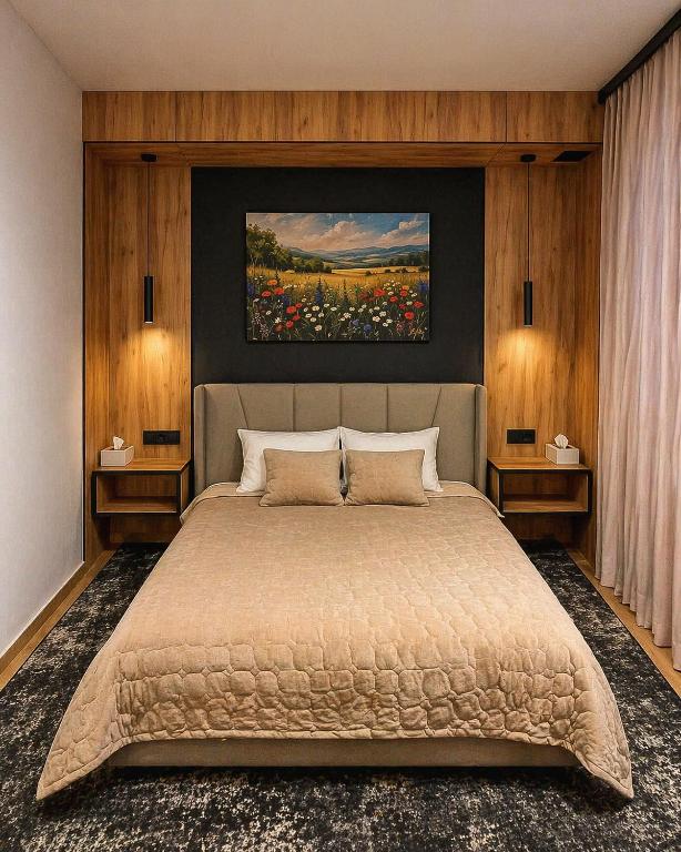 a bedroom with a bed with a painting on the wall at Hostel Olevsk in Olevsk