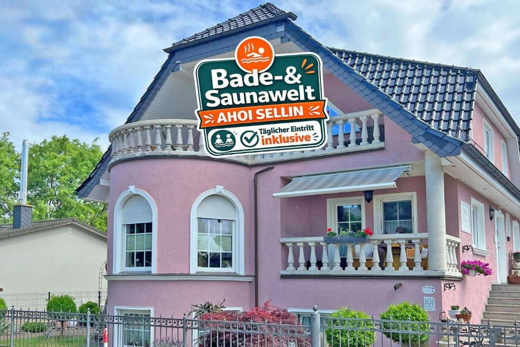 a pink house with a sign for a restaurant at Villa Vivien, Ostsee Donnerkeil App 2 - Bade- & Saunawelt täglich inklusive in Göhren