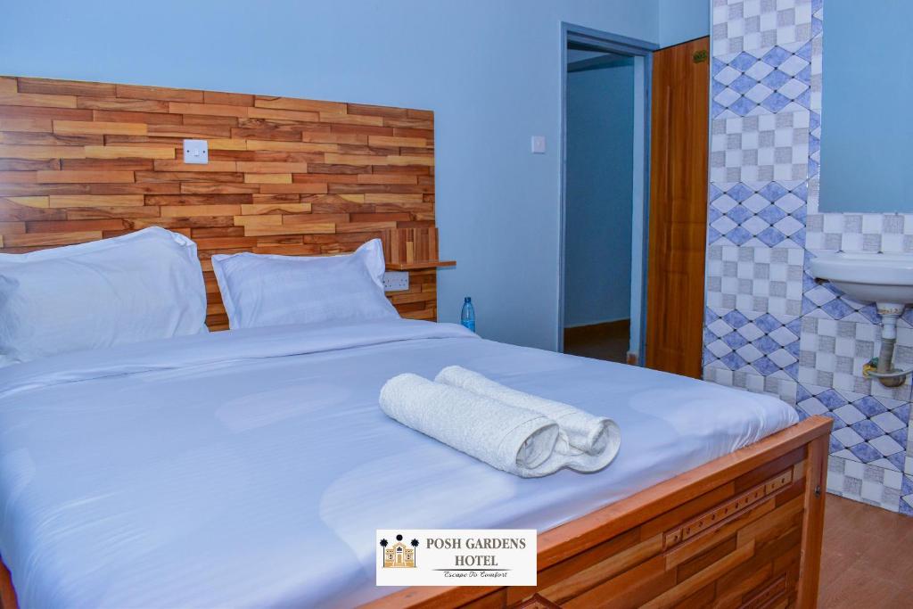 a bedroom with a bed with two towels on it at Posh lounge gardens in Gatimu