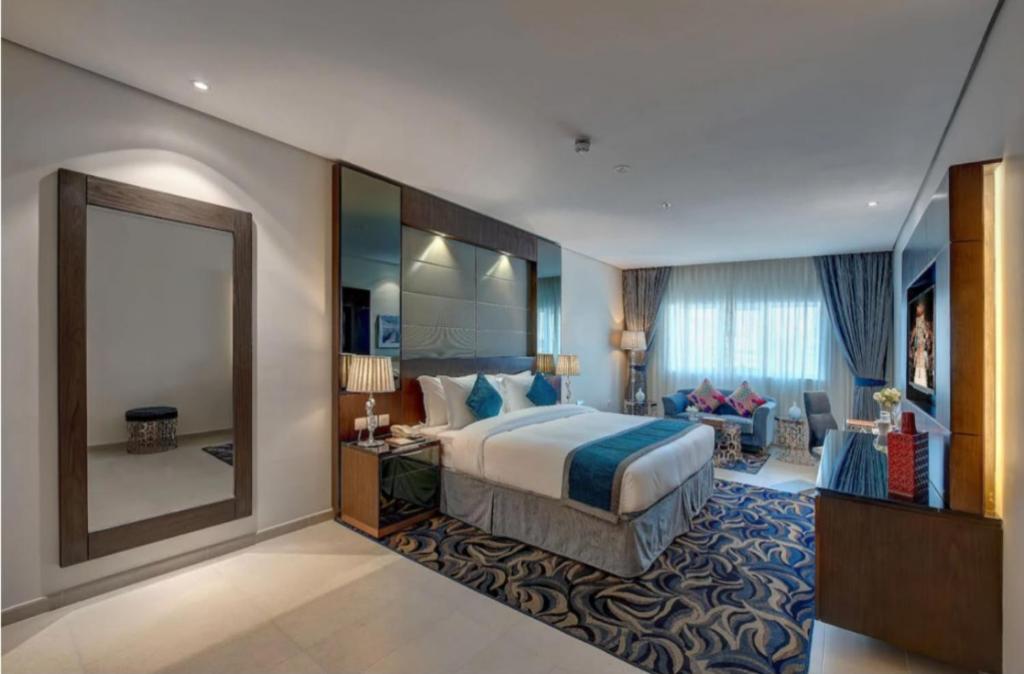 a hotel room with a bed and a large mirror at Hotel The De - Pacific Suites Near Delhi IGI Airport in New Delhi