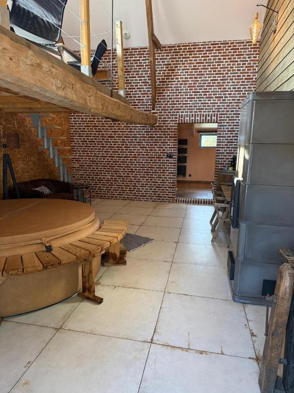 a room with a wooden bench and a brick wall at Odyssée - Chambre d'hôtes avec sauna privatifs, spa et filet suspendu in Zeggers-Cappel