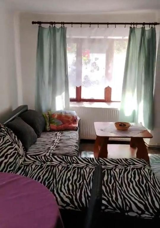 a living room with a zebra couch and a table at Vejminek u hospodářství Obora u Doks in Doksy