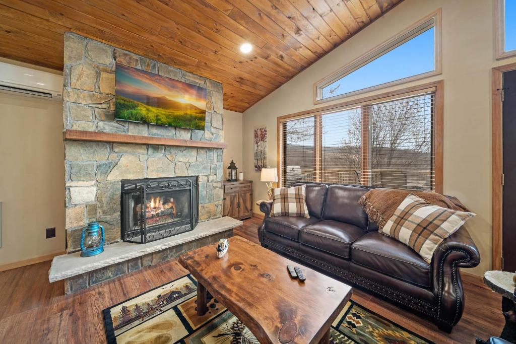 a living room with a leather couch and a fireplace at On Beech Time in Beech Mountain