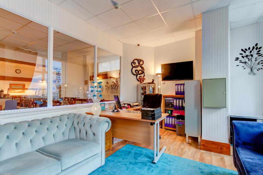 a living room with a couch and a desk with a computer at Sutton Park Guest House in Blackpool