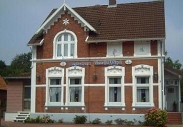 a brick building with white windows and a brown roof at Goode Wind in Norden