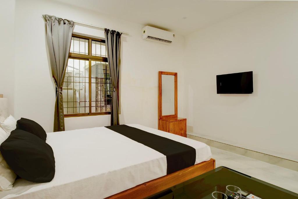 a bedroom with a bed and a television in it at SPOT ON Golden Eagle Residency in Barpeta