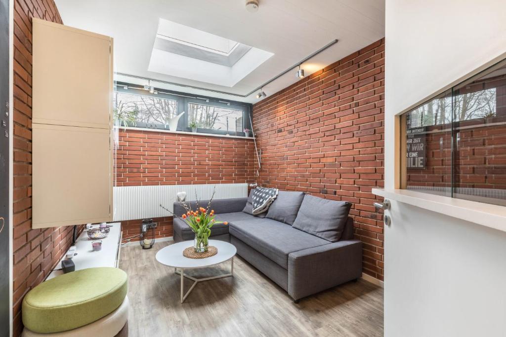 a living room with a couch and a brick wall at Ferienwohnung Stillblick in Gersthofen