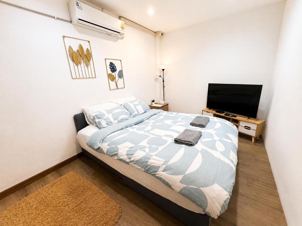 a bedroom with a bed and a flat screen tv at Terlyn Hostel & Cafe in Amphoe Phra Khanong