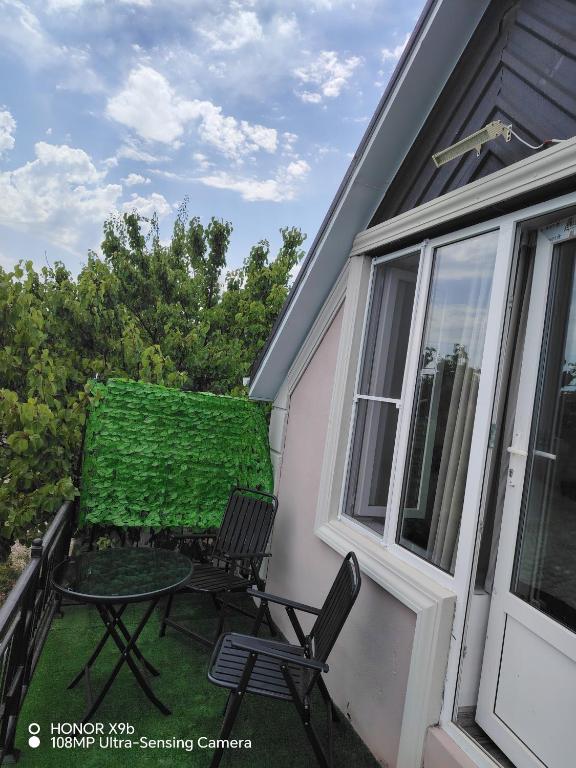eine Terrasse mit zwei Stühlen und einem Tisch auf einem Balkon in der Unterkunft AGA Frame in Qusar