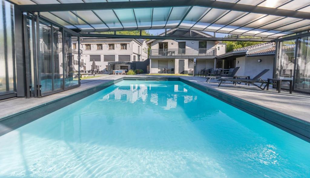 a swimming pool with blue water in a building at Hotel Val de l'Our in Burg-Reuland