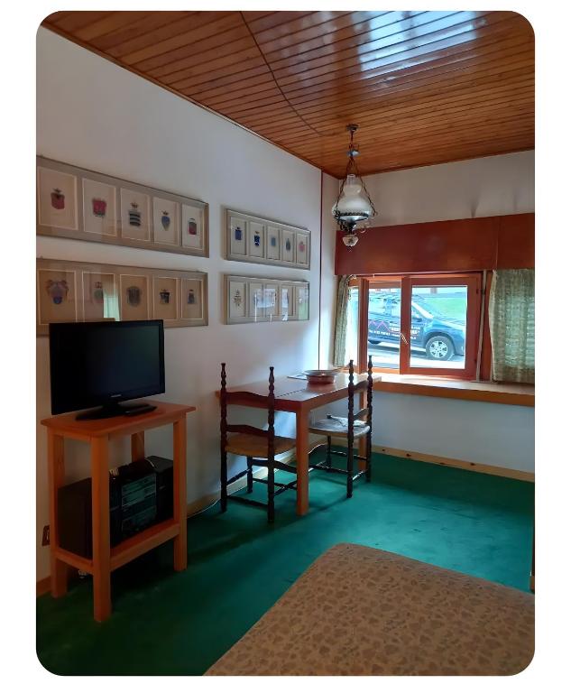 a living room with a table and a television at Appartamento Sestriere in Sestriere