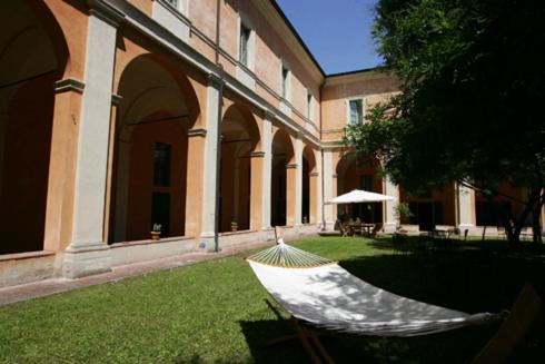 uma rede sentada na relva em frente a um edifício em Student's Hostel Della Ghiara em Reggio Emilia