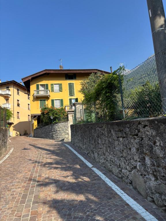 a cobblestone street in front of a yellow building at Villa Coppa Hotel in Dazio