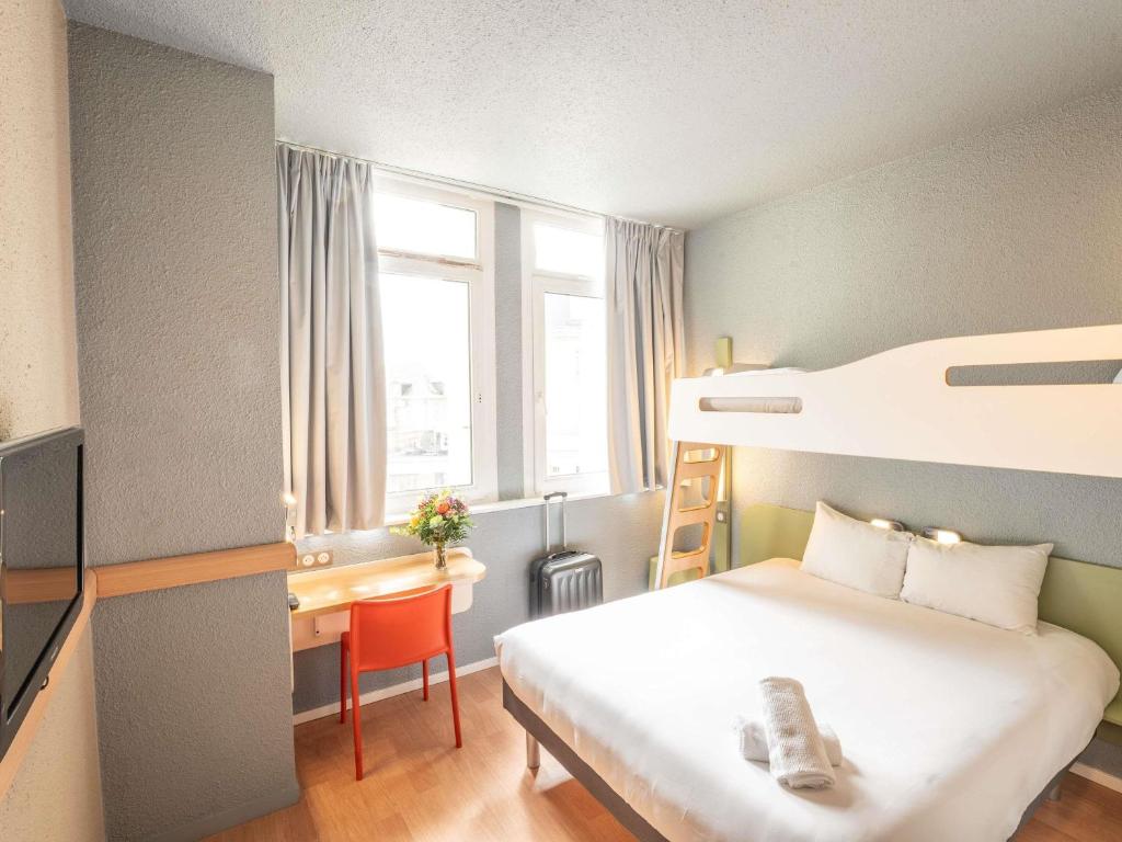 a hotel room with a bed and a desk and a bunk bed at ibis budget Le Mans Centre in Le Mans