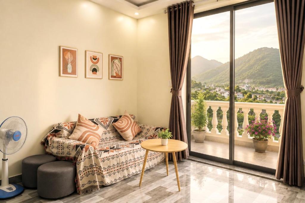 a living room with a couch and a large window at Cat Ba Sky Home in Cat Ba