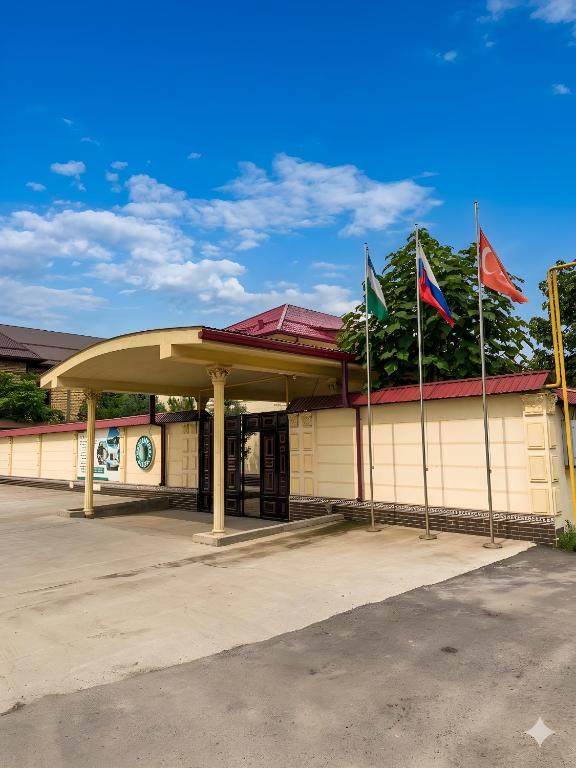 a building with three flags in front of it at GREEN APPLE GUEST House in Tashkent