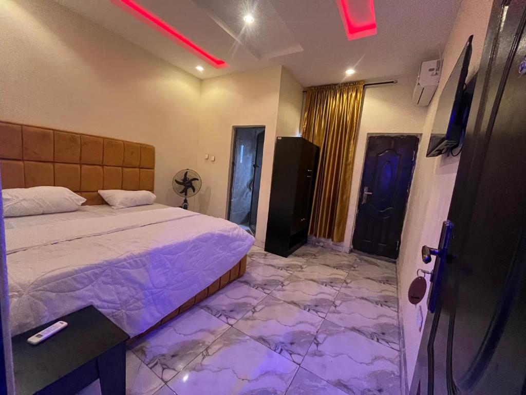 a bedroom with a bed and a floor covered in marble at Etsuko hotel and suites world city in Atan