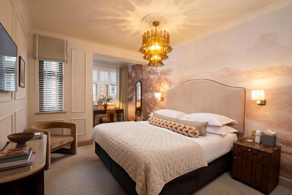 a bedroom with a large bed and a chandelier at The Capital Hotel, Apartments & Townhouse - Small Luxury Hotels of The World in London