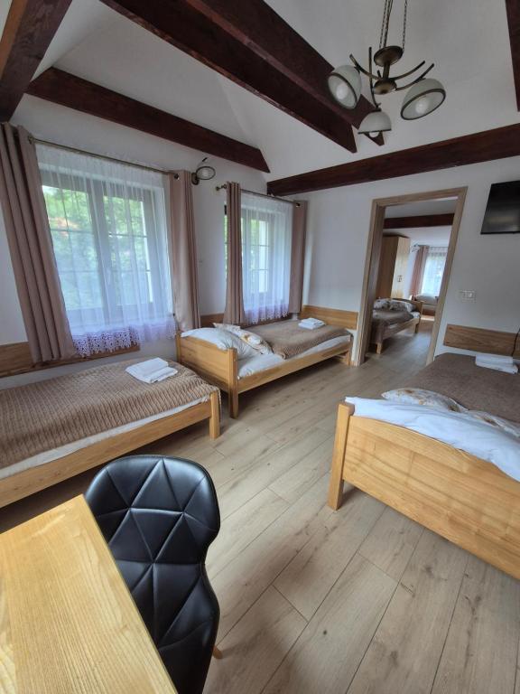 a large room with two beds and a chair at Dom Krawca - pod Chojnikiem in Jelenia Góra