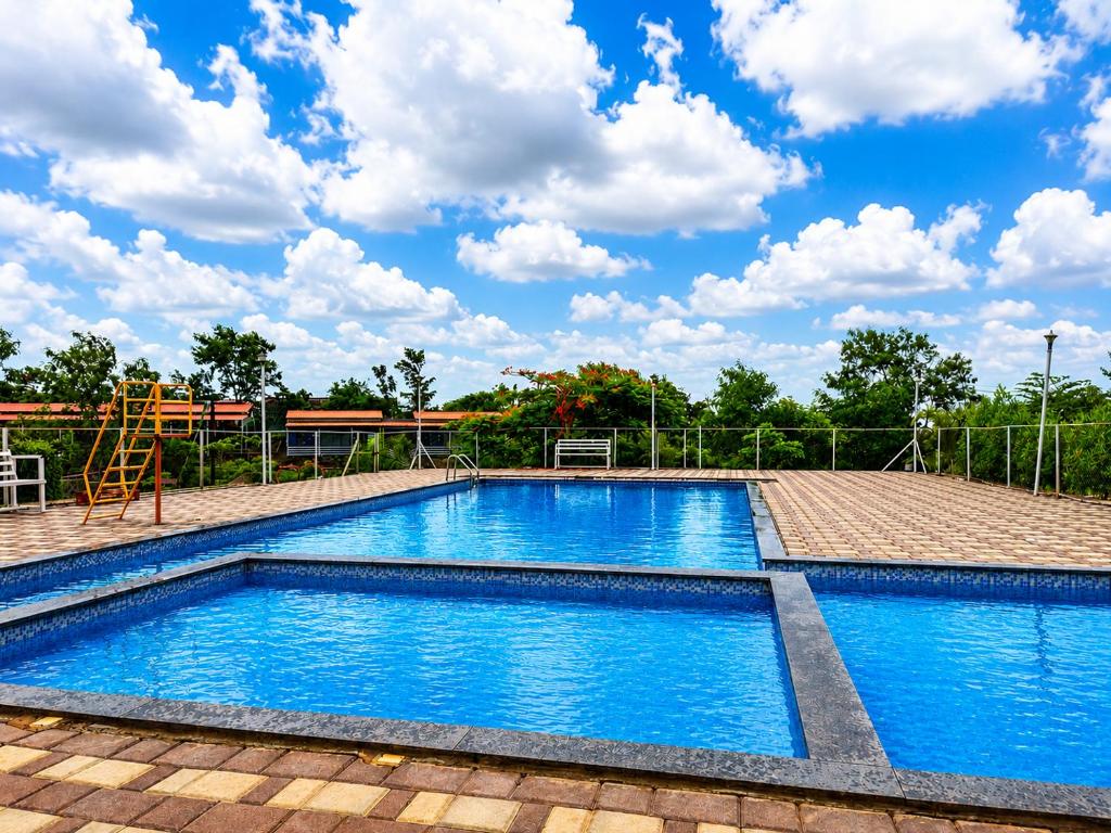 a swimming pool with a playground and a volley ball at Royal Villa Resort in Sāngli