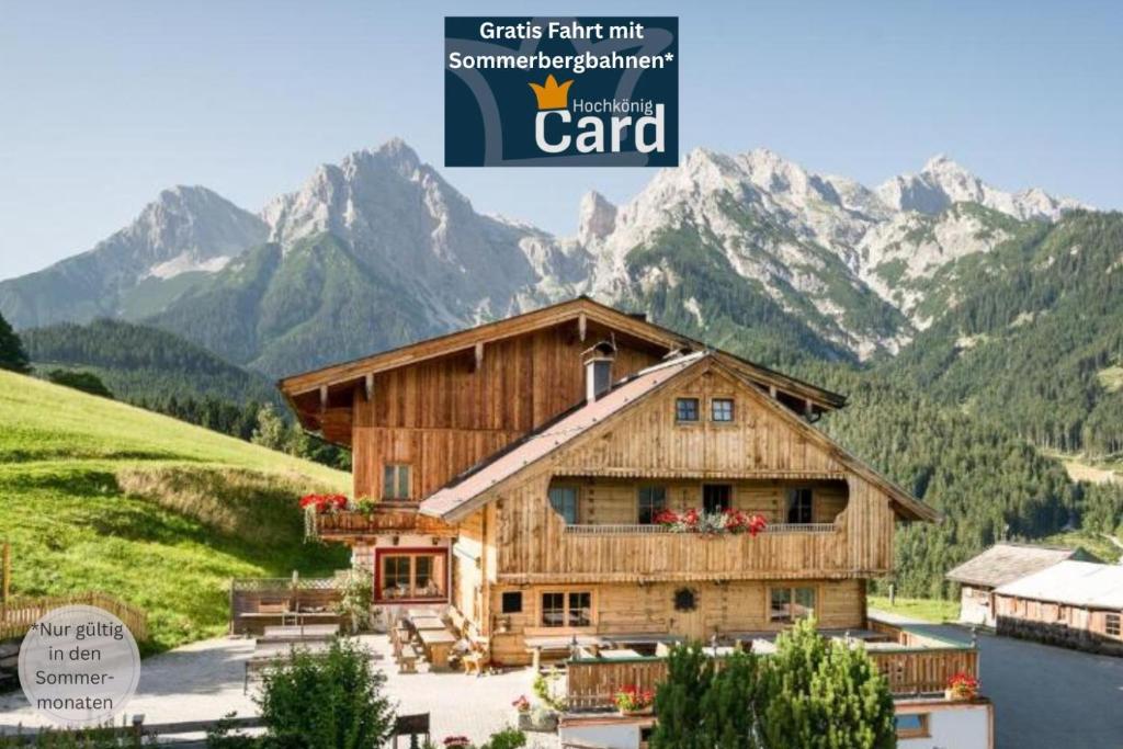 a magazine picture of a house with mountains in the background at Gasthof Kronreith in Maria Alm am Steinernen Meer