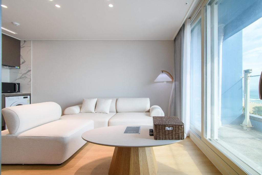 a living room with a white couch and a table at 플럼바고올스위트402 in Chosan-ni